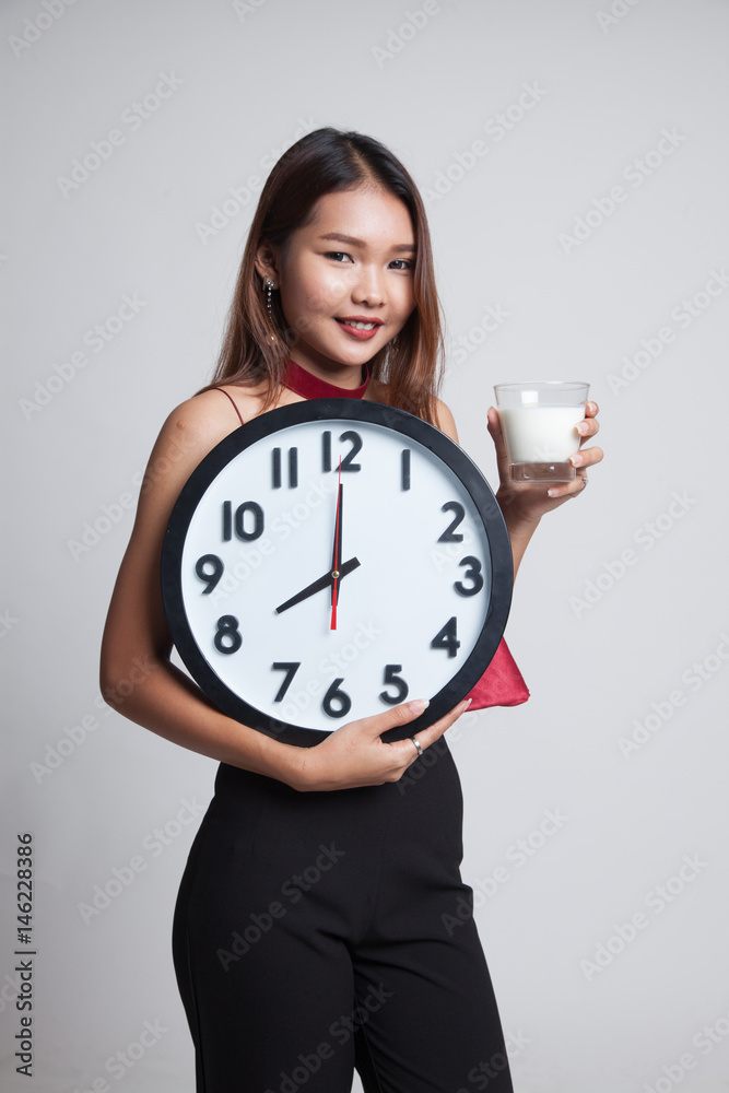 Healthy Asian woman drinking glass of milk hold clock. Healthy Asian woman drinking glass of milk hold clock.