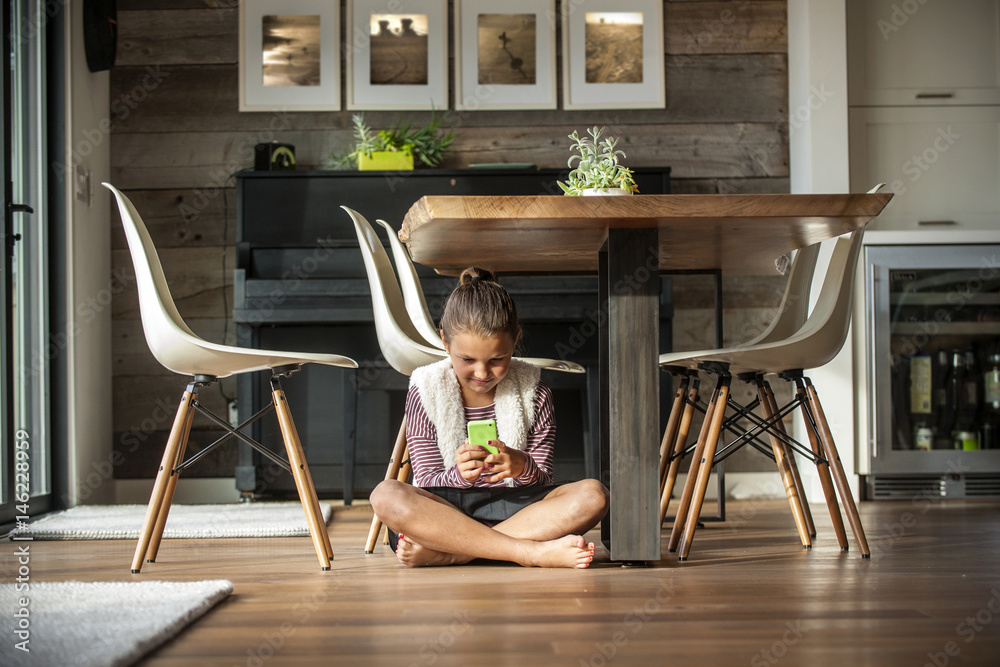 Girl sitting on floor texting on cell phone Girl sitting on floor texting on cell phone
