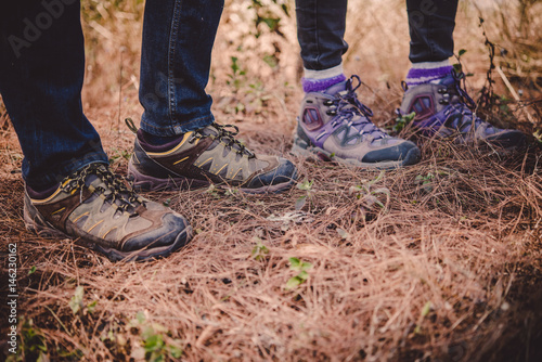 Close-up of legs of  hikers standing on the forset. © Lealnard