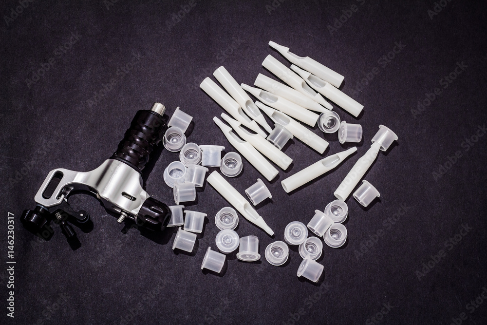 tattoo machine caps needles and grips on black background tattoo machine caps needles and grips on black background