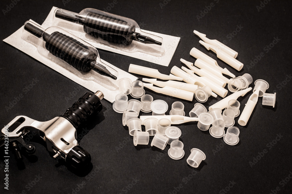 tattoo machine caps needles and grips on black background tattoo machine caps needles and grips on black background