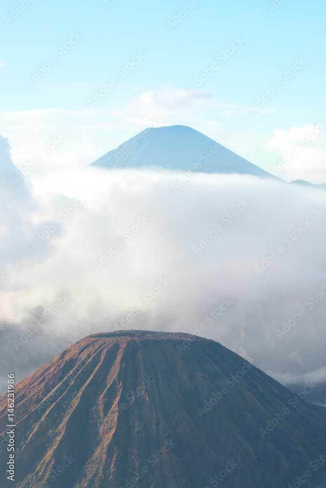 Mount Bromo, an active volcano surrounded by white clouds of mist in the morning at the Tengger Semeru National Park in East Java, Indonesia.