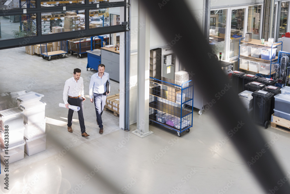 Two businessmen walking in factory shop floor Two businessmen walking in factory shop floor