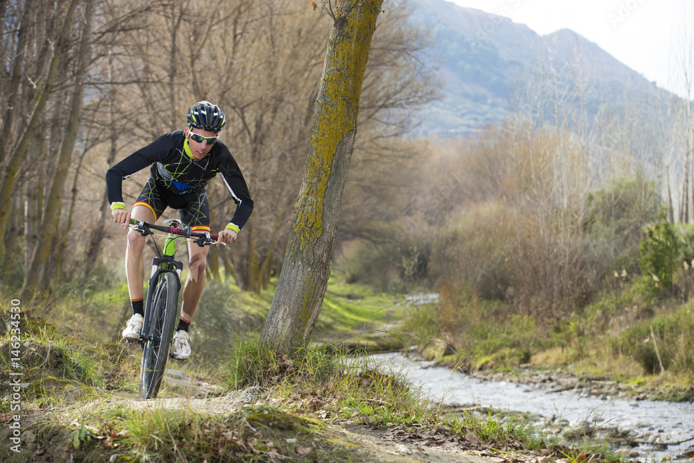 Obraz premium Cyclist man riding mountain bike on mountain.