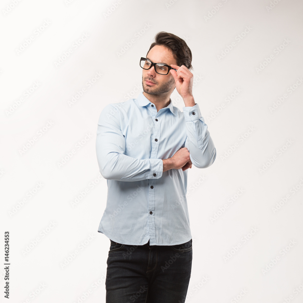 Young happy man showing presentation, pointing on placard over gray background