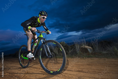 Cyclist man riding mountain bike on mountain.