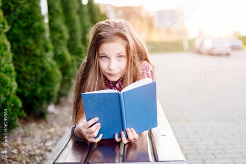 Ten years old blue eye blonde girl reading book