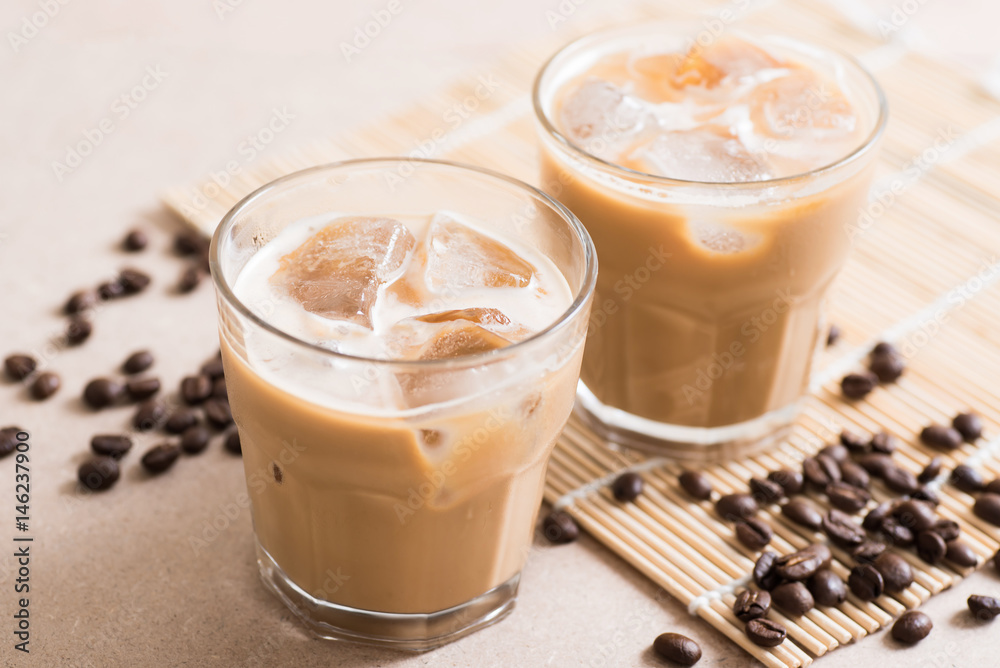 Glass of ice coffee with coffee bean on wooden background Glass of ice coffee with coffee bean on wooden background