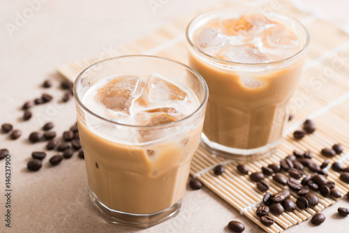 Glass of ice coffee with coffee bean on wooden background