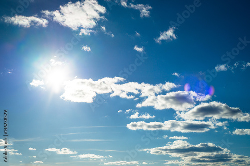 Clouds in the sky. Blue sky background with clouds and sun. © nadianb