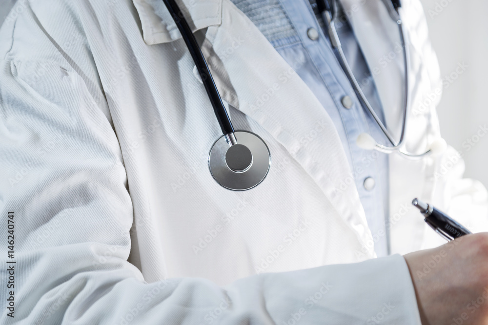Medical doctor on white background holding a stethoscope. Focus on the stethoscope. Medical doctor on white background holding a stethoscope. Focus on the stethoscope.
