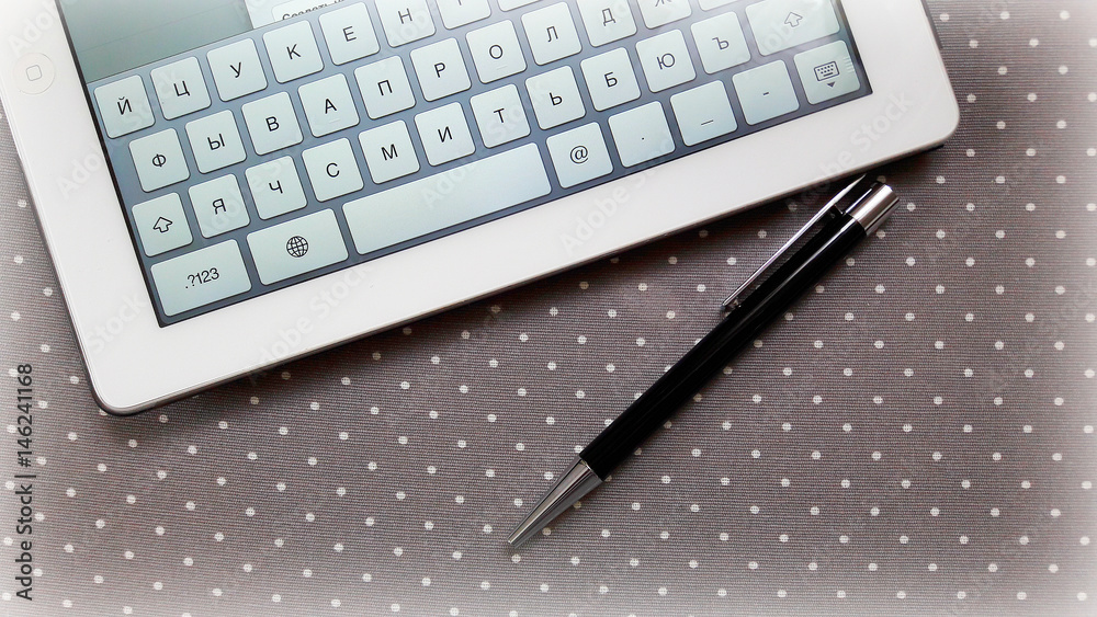 Computer keyboard and black feather on a background of grey cloth with white spots. Computer keyboard and black feather on a background of grey cloth with white spots.