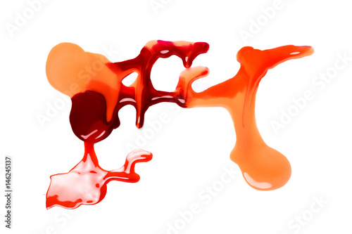 spilled colorful nail polish on white background. red and yellow paint stains.