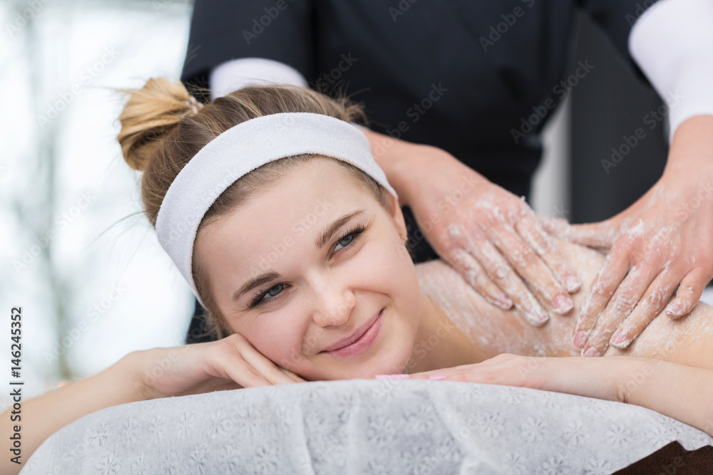 Woman getting exfoliating salt scrub massage at beautician's Woman getting exfoliating salt scrub massage at beautician's
