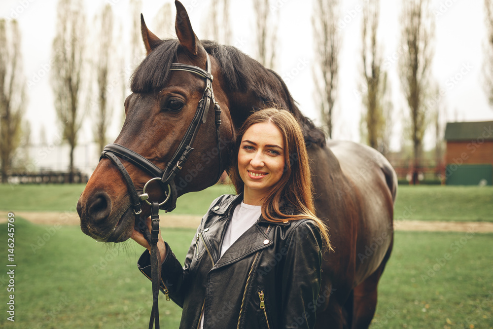 Beautiful girl communicates with the horse in the park. Preparing for ...