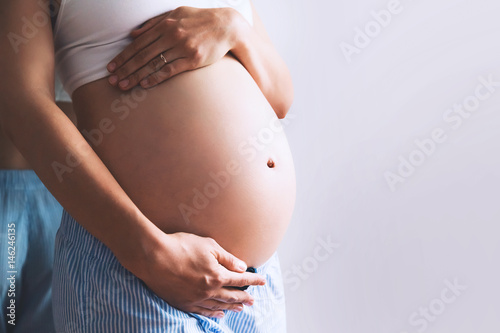 Close-up pregnant woman's belly on white background