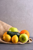 various fruits: lemon, apple, orange, avocado on sackcloth napkin