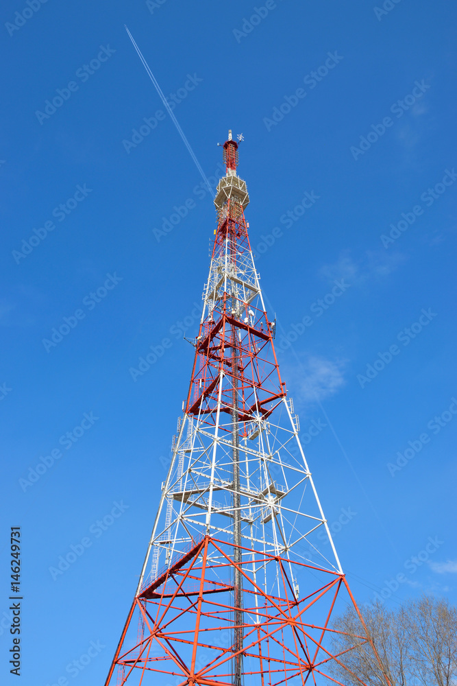 Television tower on the background of an airplane in the blue sky Television tower on the background of an airplane in the blue sky