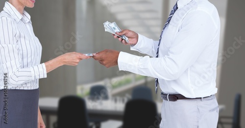 Картината върху платно Midsection of businessman giving money to employee in office