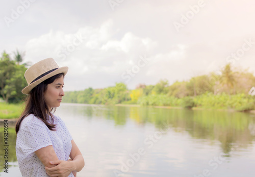 young beautiful woman relaxing in park nearby lake