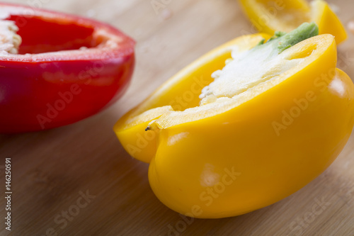 Cut vegetables on a wooden board. Red and yellow peppers, Broccoli. photo