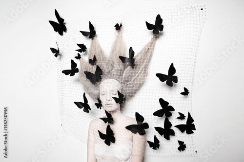 Pale woman in cocoon with butterflies  photo