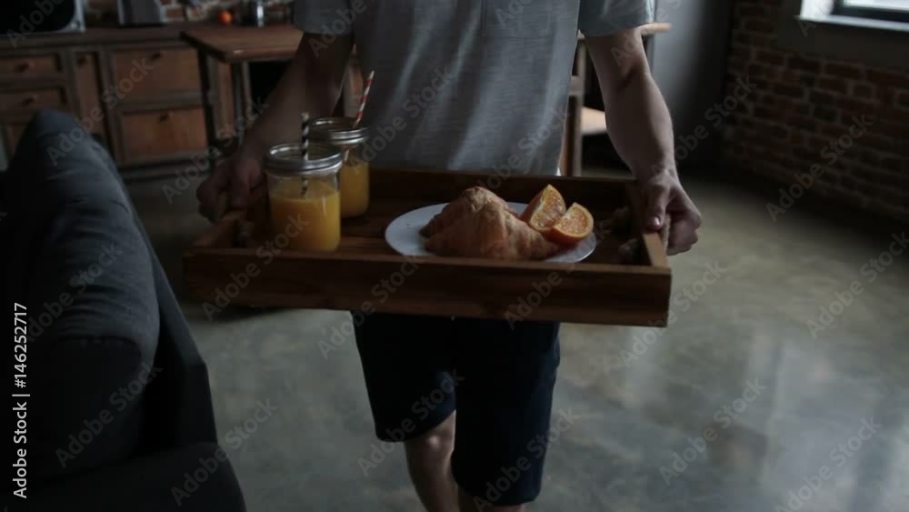 Man serving breakfast on wooden tray in bed Man serving breakfast on wooden tray in bed