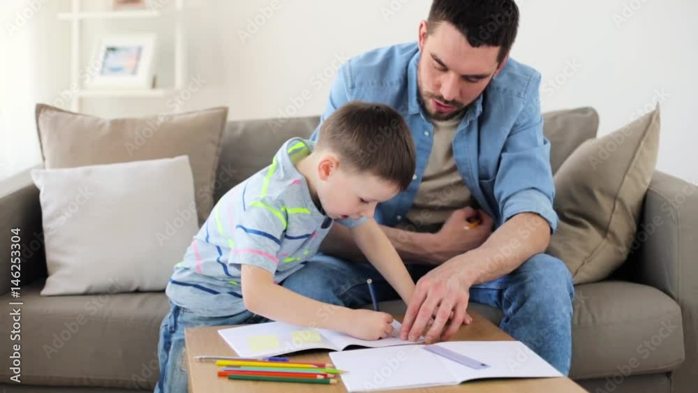 father and little son with crayons drawing at home