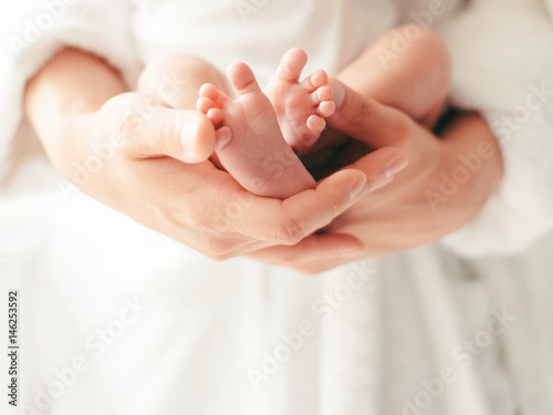 Parent holding in hands feet of newborn baby