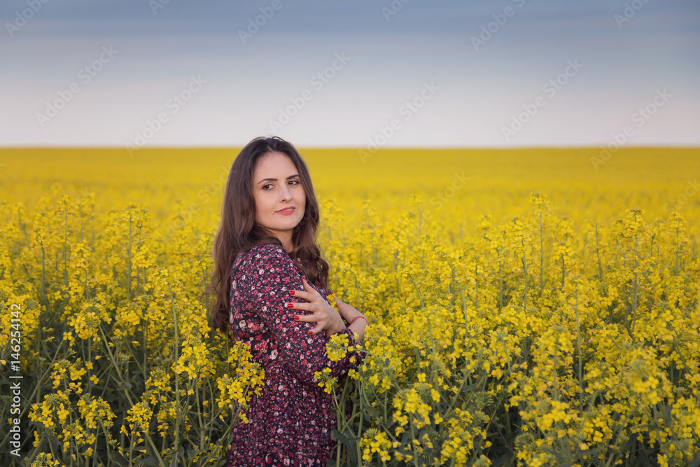 Spring portrait of a woman in the rapeseed field
