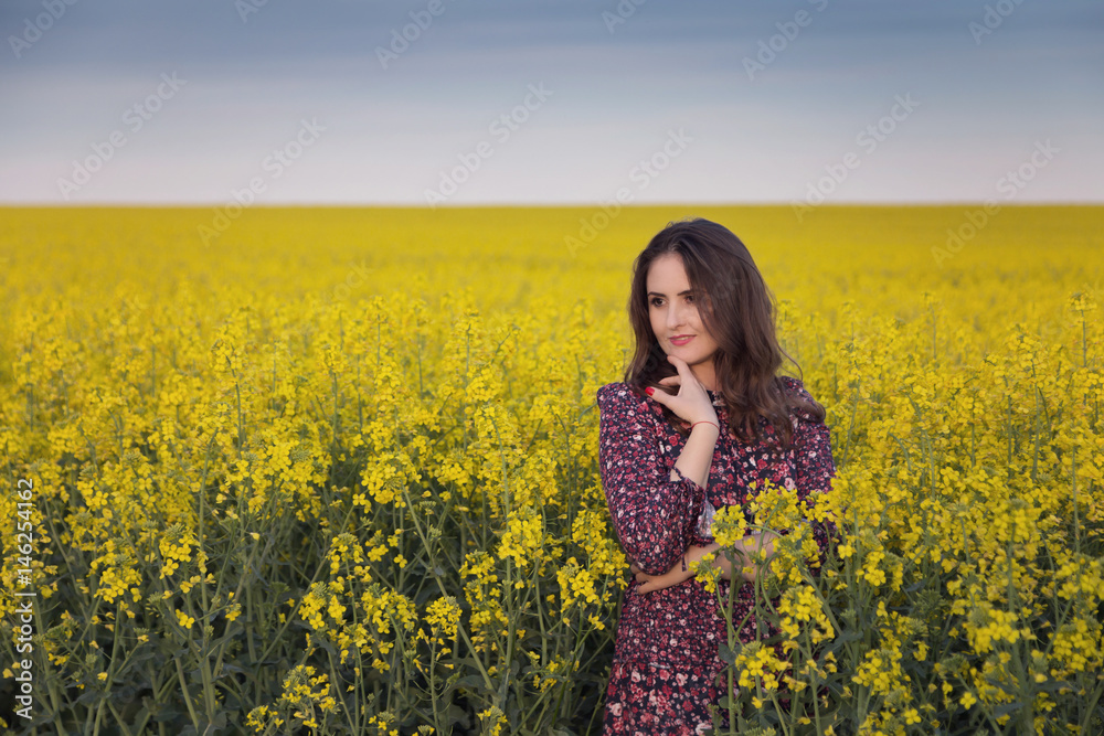 Spring portrait of a woman in the rapeseed field
