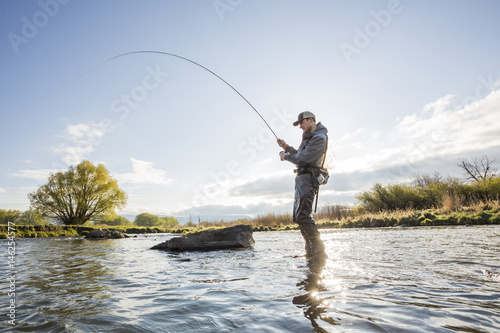 Caucasian man fly fishing in river
