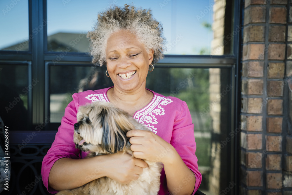 Black woman hugging dog near window Black woman hugging dog near window
