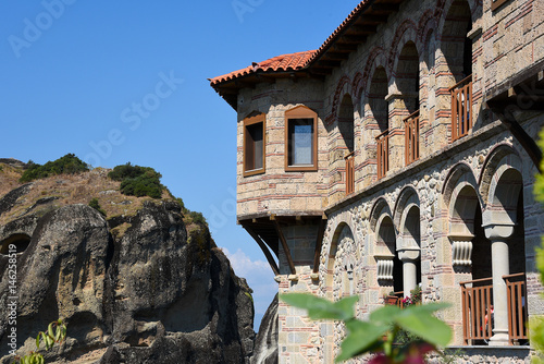 Old fortress with red roofs standing oh hill under blue cloudy sky..