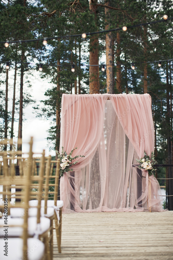 Golden chairs stand on the porch before pink wedding altar Golden chairs stand on the porch before pink wedding altar