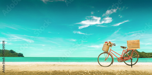 Red vintage bicycle on white sand beach over blue sea and clear blue sky background, spring or summer holiday vacation concept,vintage style.