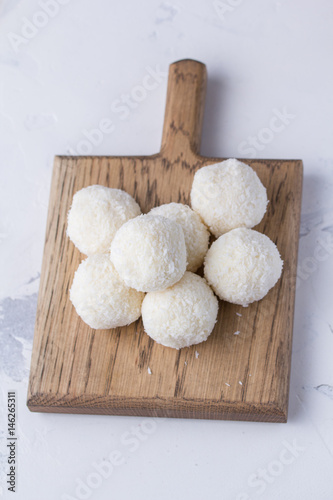 Coconut candy on a wooden board. Round coconut balls photo
