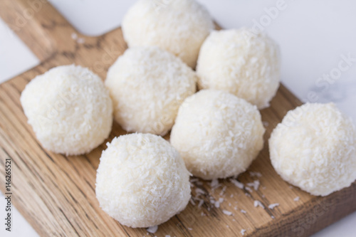 Coconut candy on a wooden board. Round coconut balls