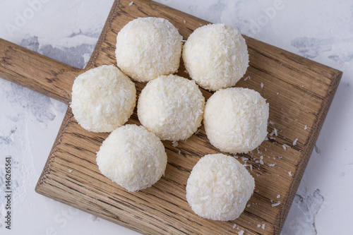 Coconut candy on a wooden board. Round coconut balls photo