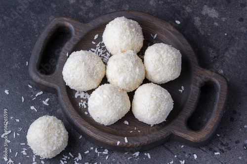 Coconut candy on a wooden board. Round coconut balls photo