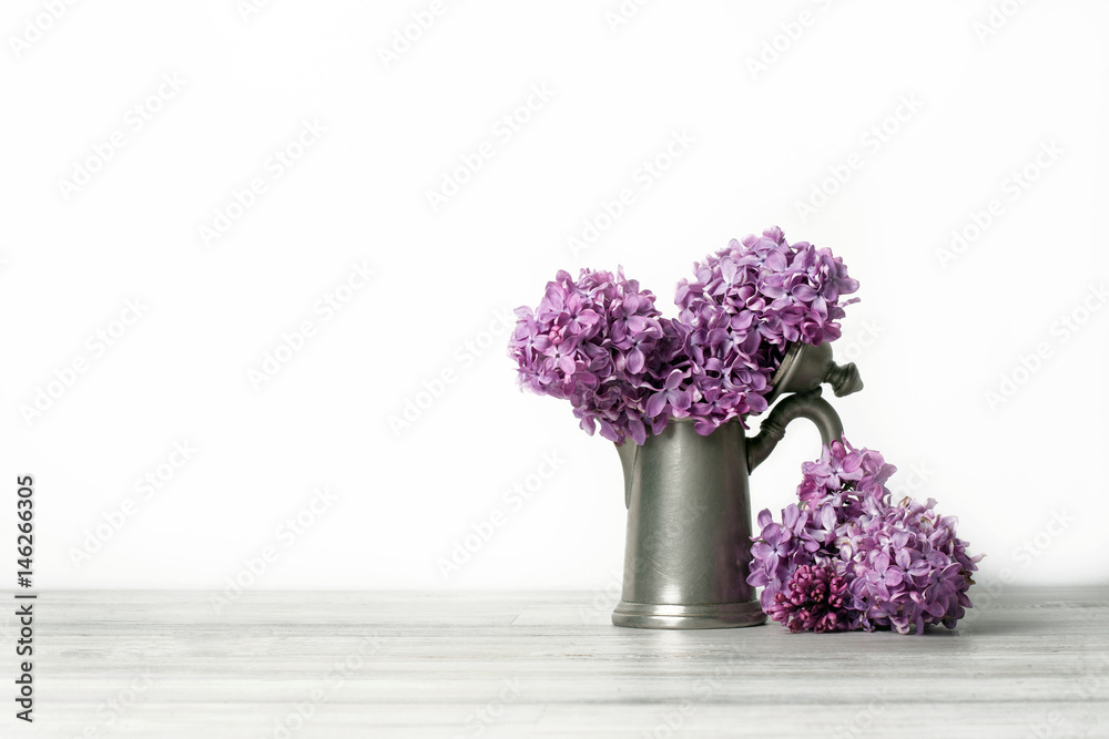 Stylish old kettle,branch of lilac on white background