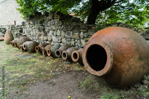 Old traditional wine jars, called Kvevri, lined in a row, by a monastery in Telavi, Georgia.