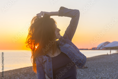 Young attractive woman on the beach at sunset time