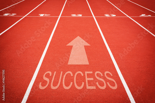 word "SUCCESS" and athletic track number on red rubber racetrack, texture of runnin.