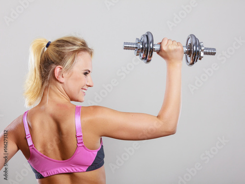 Fit woman lifting dumbbells weights