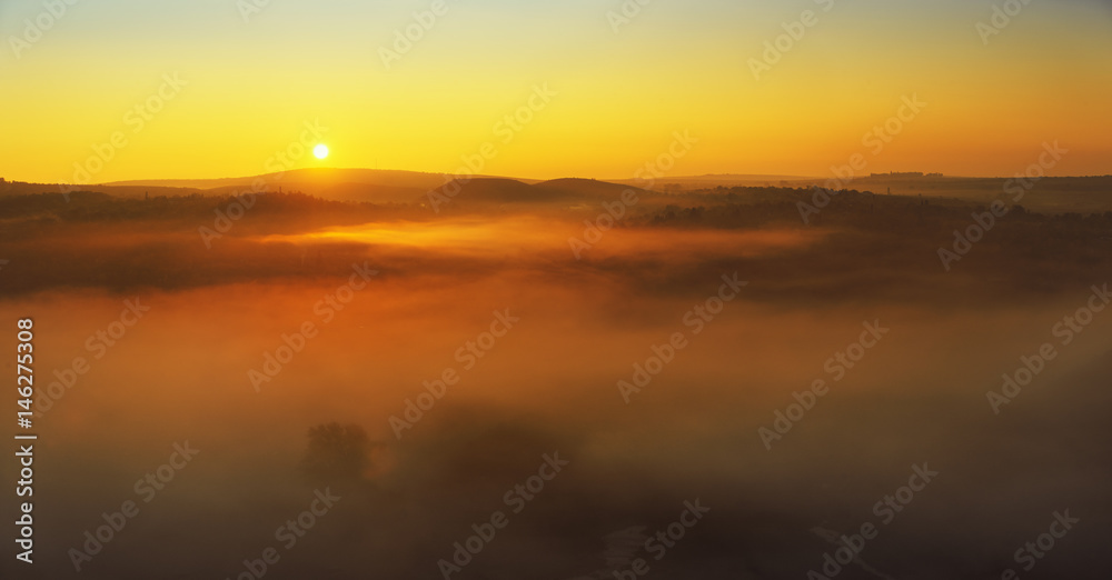 Foggy hill in autumn shot at sunrise