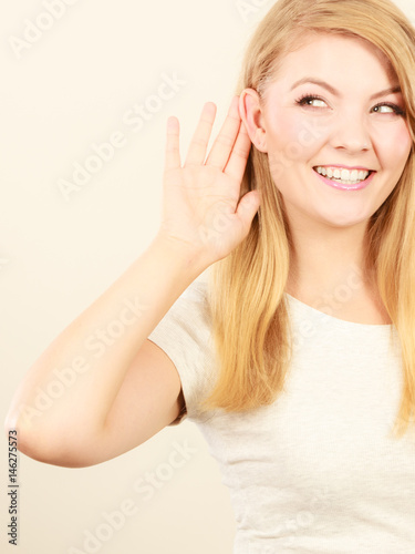 Woman putting hand ear to hear better