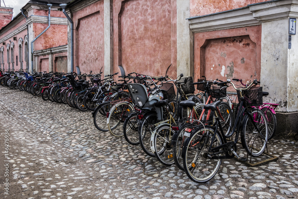 The parking lot for bicycles near an old wall in an european city.