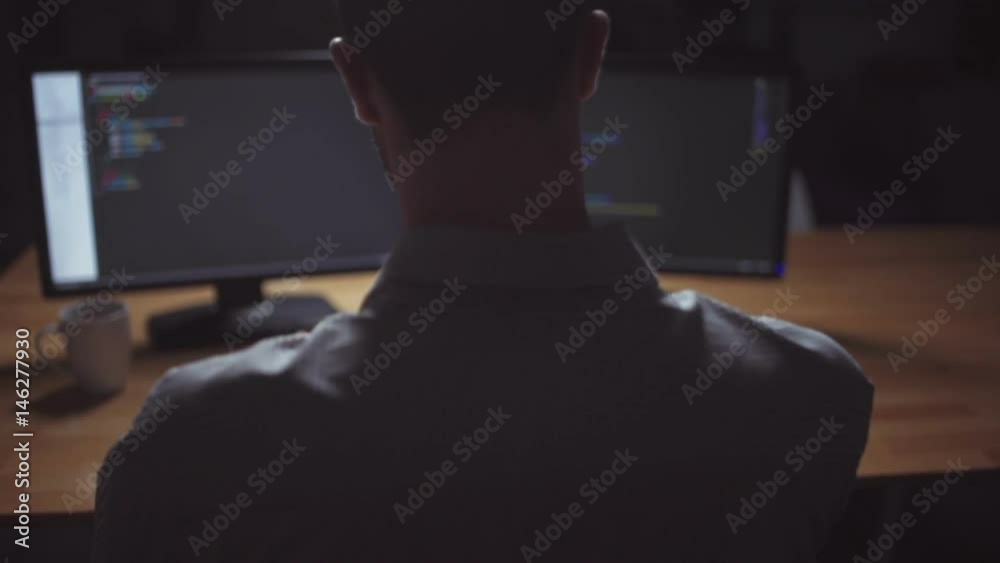 Rear view of freelancer programmer working at night