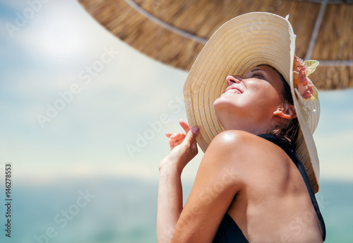 Woman in big straw hat enjoyed with summer sun